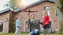 Ein Vater, der mIt seinen Kindern vor dem eigenen haus spielt. Für viele Deutsche platzt der Traum vom, Eigenheim, aufgrund der finanziellen Situation