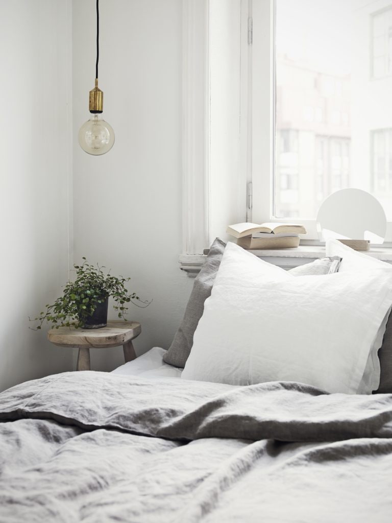 Scandinavian bedroom with pendant light next to the bed