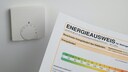 Energieausweis vor einem Heizungsregler f&uuml;r die Fu&szlig;bodenheizung