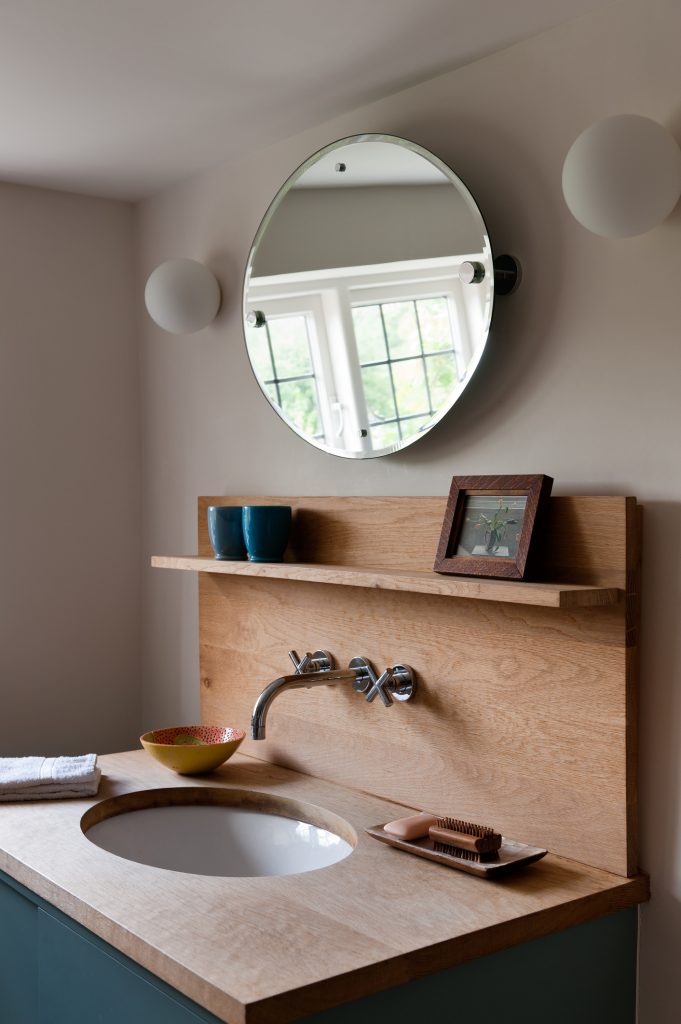 Round, frameless mirror in a modern country bathroom