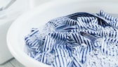 Blau-weiß gestreiftes Hemd in einer Wanne mit Wasser