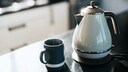 Kanne und Tasse auf Arbeitsplatte aus Keramik