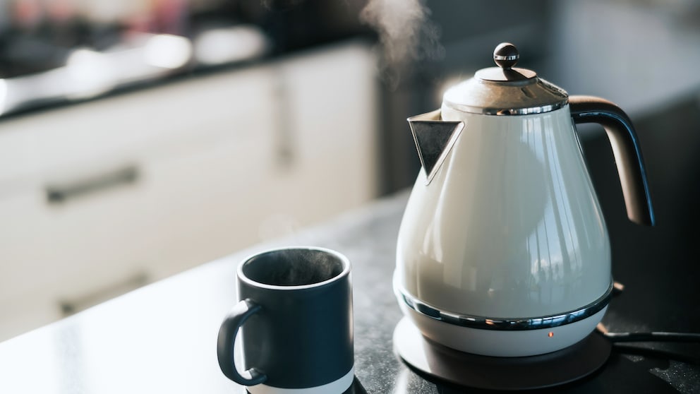 Kanne und Tasse auf Arbeitsplatte aus Keramik