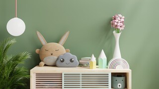 Stauraummöbel im Kinderzimmer vor grüner Wand