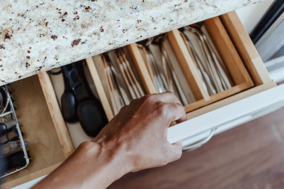 Person pulling out a cutlery drawer