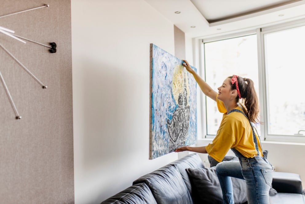 Woman hanging a picture on the wall