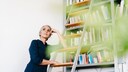 Frau auf Leiter im Wohnraum