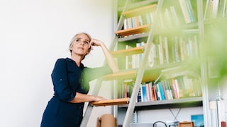 Frau auf Leiter im Wohnraum