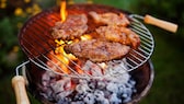 Fleisch auf einem Grillrost von einem Holzkohlegrill