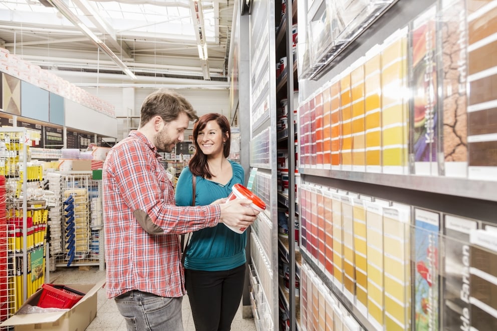 Couple buying dispersion paint at the hardware store
