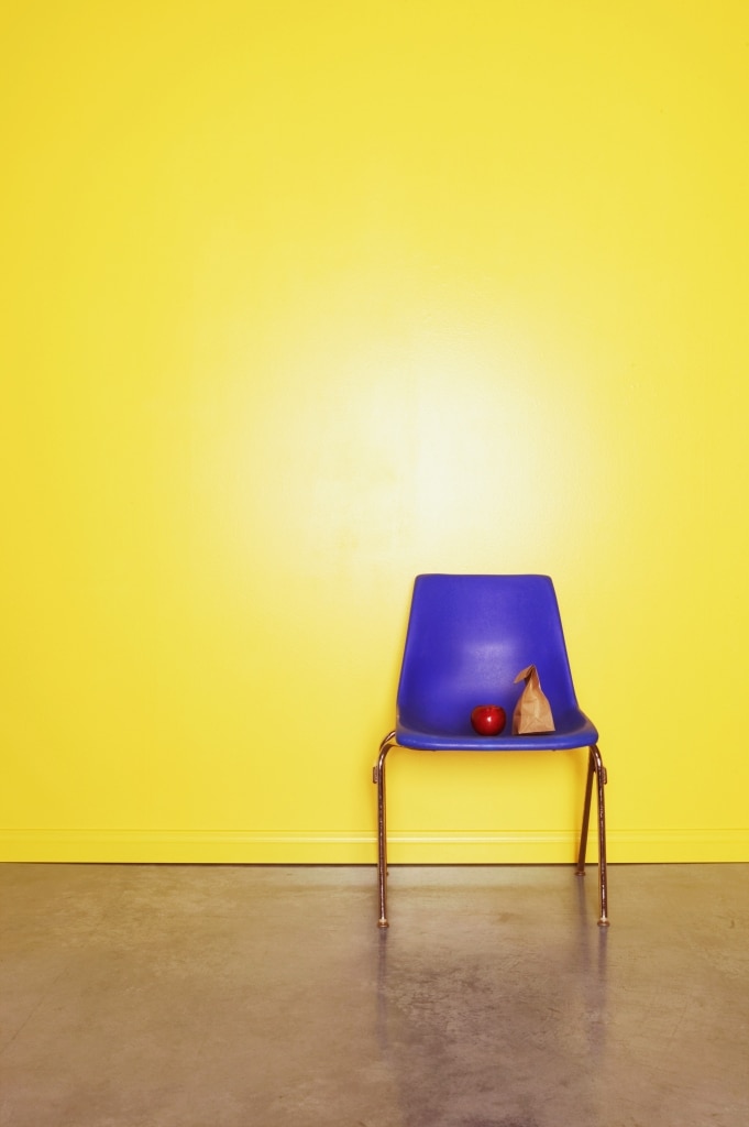 Violet chair against a yellow wall