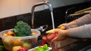 Jemand w&auml;chst Obst und Gem&uuml;se unter flie&szlig;endem Wasser