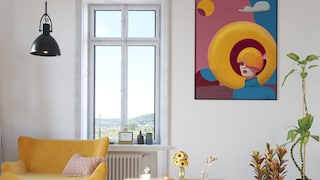 Wohnzimmer mit knallgelbem Sofa und übergroßem Bild an der Wand