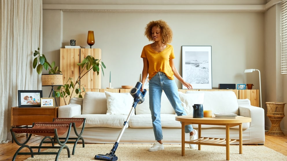 Frau mit 3-in-1-Staubsauger in der Wohnung