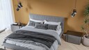 Schlafzimmer mit farbiger Wand, gepolstertem Bett(Haupt) und tiefhängenden Nachttischleuchten