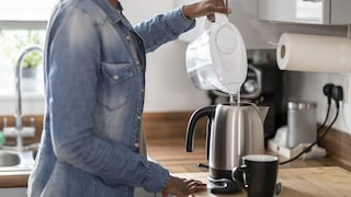 Frau mit Wasserfilter-Kanne in der Hand