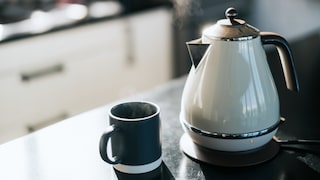 Wasserkocher mit Tasse auf dem Tisch