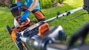 Orangefarbener Akku-Rasenmäher im Garten