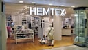 Frau steht vor einem Hemtex-Laden