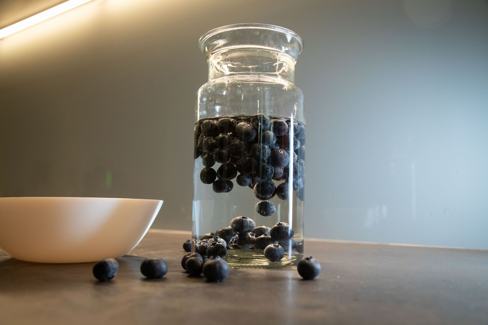 Blaubeeren schwimmen in einem Glas mit Wasser