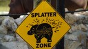 Ein Schild warnt vor der Eigenart der Flusspferde, ihren Kot zu versprühen