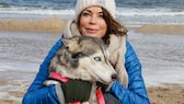 Gerit Kling und ein Husky beim Hundeschlittenrennen am Strand