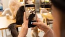 Frau mach ein Foto mit ihrem Smartphone von ihren beiden Katzen