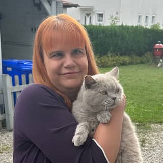 Porträt-aufnahme von PETBOOK-Redakteurin Natalie Dekcer mit Katze auf Arm