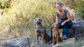 Dr. Mareike Schneider und ihrem Hündinnen Smilla (links) und Majvi (rechts). Die Biologin arbeitet seit 2016 mit ihren Artenspürhunden im Naturschutz