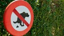 Ein Schild verbietet Hunden, auf die Wiese zu machen