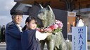 Zwei Japaner legen an der Statue von Hachiko einen Blumenkranz ab