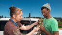 Tierärztin mit Hundebesitzer bei der Impfung eines Welpen gegen Tollwut in Südafrika