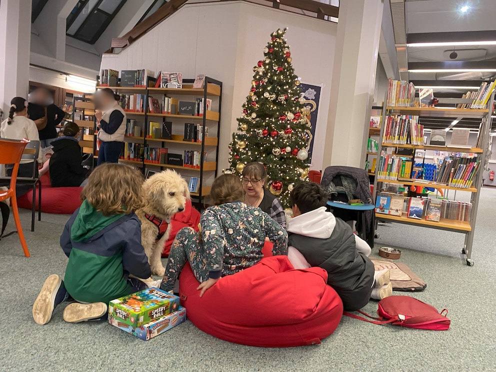 Lesehund Rudi Rakete voll in seinem Element. In der Bibliothek hilft er Kindern beim Lesenlernen. 