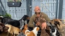 TV-Hundetrainer Andreas Ohligschl&auml;ger mit Hunden vor einem Zaun