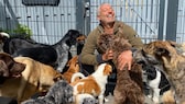 TV-Hundetrainer Andreas Ohligschläger mit Hunden vor einem Zaun