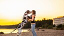 Eine Frau spielt mit ihrer Dogge am Sandstrand.