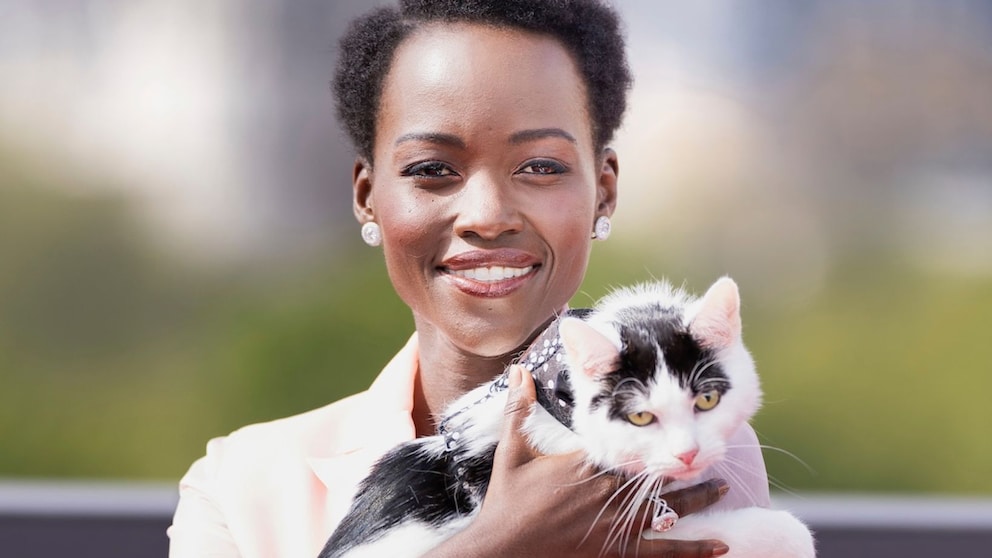 Schauspielerin Lupita Nyong’o posiert mit einer Katze.