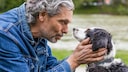 Ein älterer Mann spricht mit seinem Hund