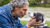 Ein älterer Mann spricht mit seinem Hund