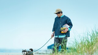 Man mit Hund hält Bücher im Arm