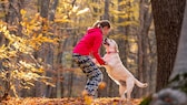 Junge Frau mit Hund im Wald