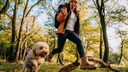 Frau ist mit ihrem Hund im Wald unterwegs