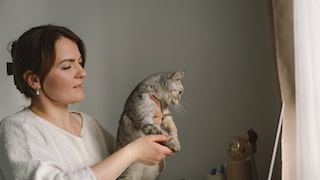 Halterin mit ihrer Katze bei einer Online-Sprechstunde beim Tierarzt