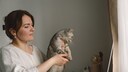 Halterin mit ihrer Katze bei einer Online-Sprechstunde beim Tierarzt
