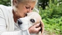 Ältere Frau kuschelt mit ihrem Hund