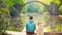 Halter und Hund vor der Rakotzbrücke in Sachsen