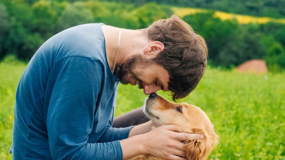 Man kuschelt mit Hund