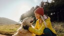 Junge Frau h&auml;lt den Kopf eine Golden Retrievers in den H&auml;nden