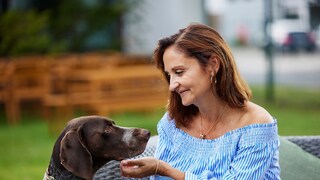 Carmen Borsche lächelnd in Interaktion mit einem Hund