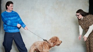 Mann hält Hund und Frau lockt